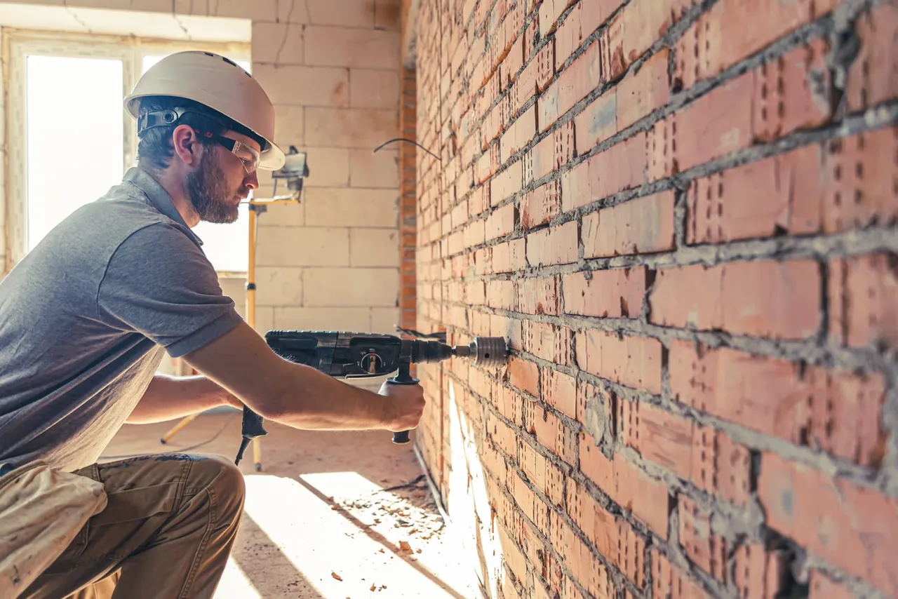 Tradesperson drilling into wall